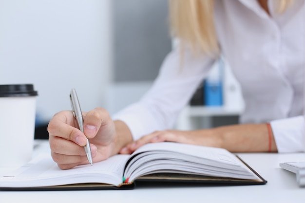 Female hand holding silver pen ready to make