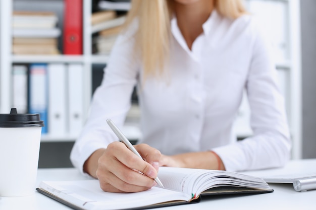 Female hand holding silver pen ready to make