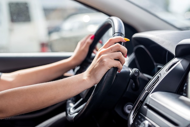 Female hand holding steering wheel Closeup