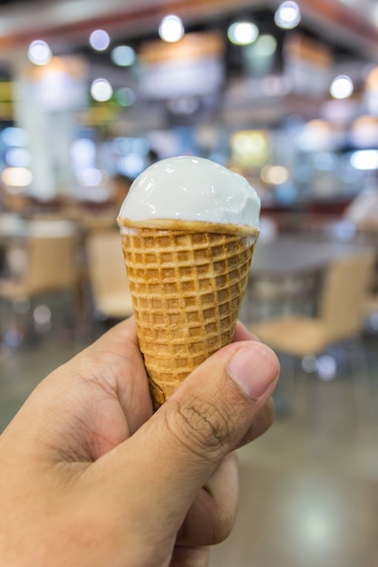 Female hand holding vanilla ice cream