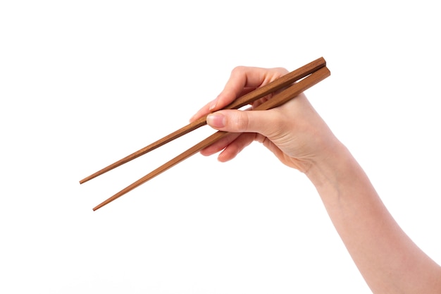 Female hand holding wooden chopsticks