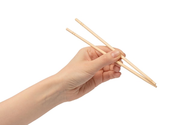 Female hand holding wooden sushi chopsticks isolated on white background