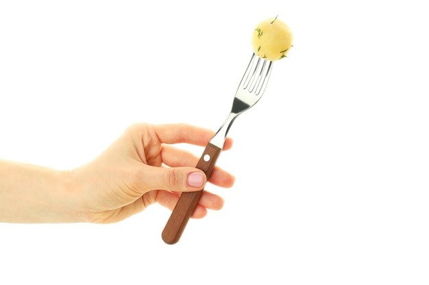 Female hand holds fork with boiled young potato isolated on white background