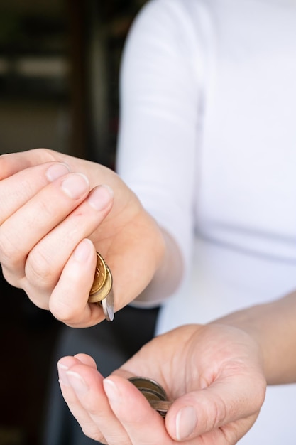 Female hand pours a small handful of coins into his palm