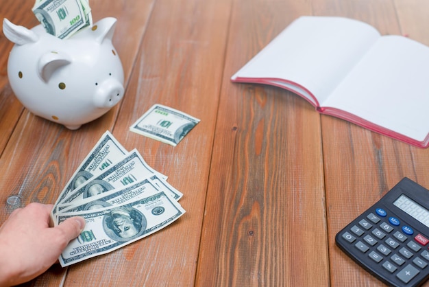 female hand puts paper money on wooden table