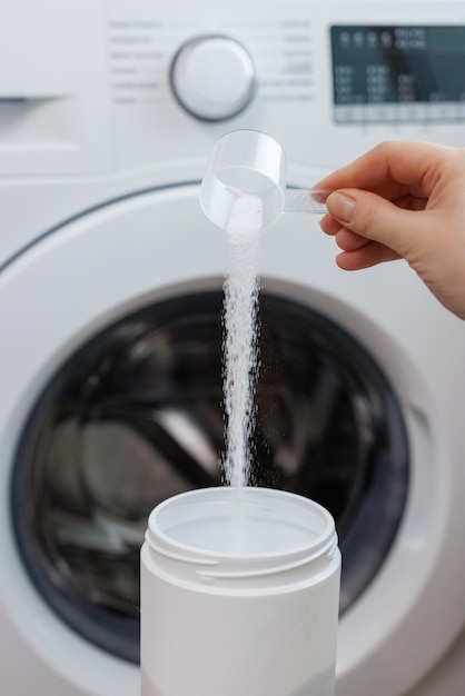 Female hand putting washing powder washing linen and clothes idea correct use of the washing machine