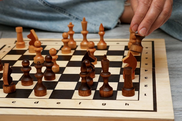 female hand rearranging pieces on a chessboard