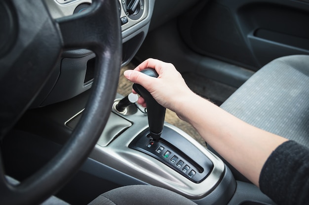 Female hand on the shift lever automatic transmission.