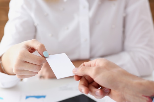 Female hand in suit give blank calling card to female