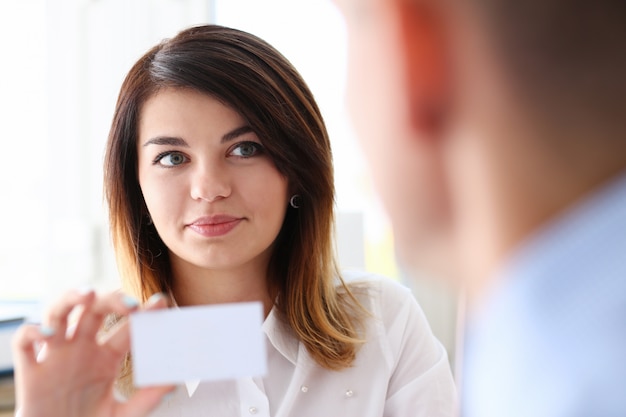 Female hand in suit give blank calling card to female