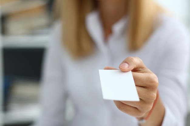 Female hand in suit giving blank card