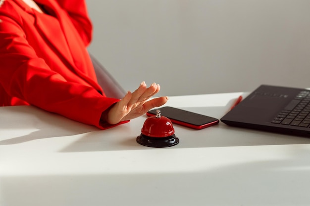 Female hand tends to press the red button on the desktop