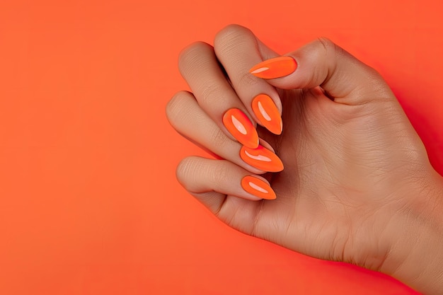 Female hand with bright orange nail design Female hand with bright orange nail polish manicure hold