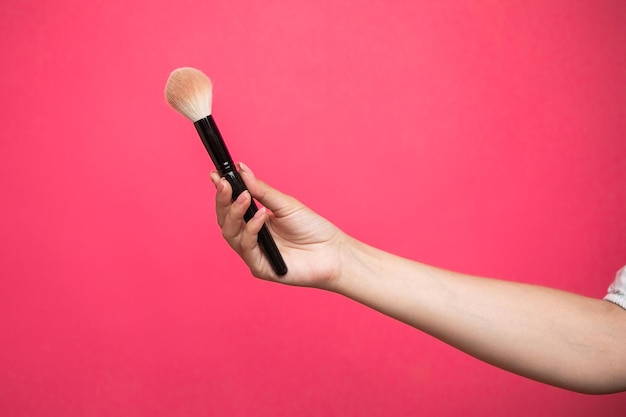 female hand with a brush for makeup