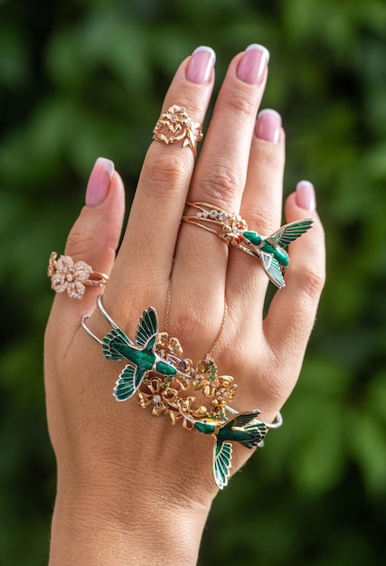 Photo female hand with jewelry on a neutral green background.