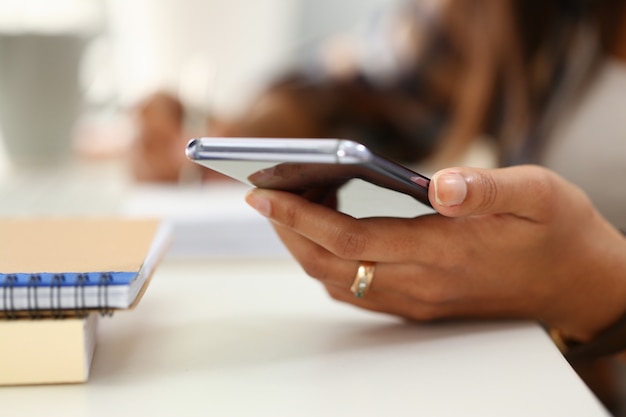 Female hand with ring holding mobile phone