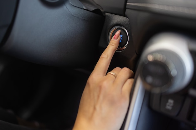 Photo female hand with start key inside car.