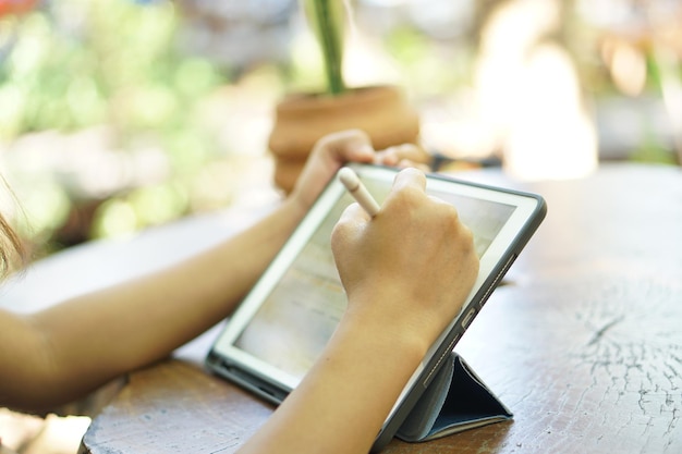 Female hand working looking at plan on computer in cafe