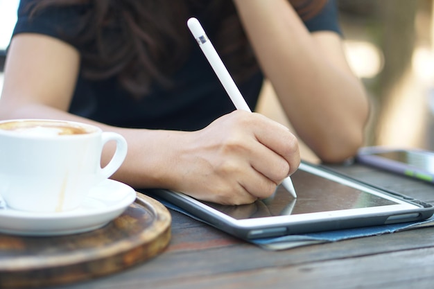 Female hand working looking at plan on computer in cafe