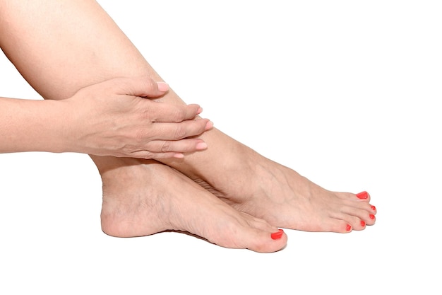 The female hand of a young woman lies on her legs On a white background