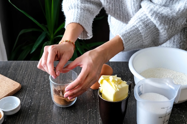 Female hands are grinding the spices for the cake