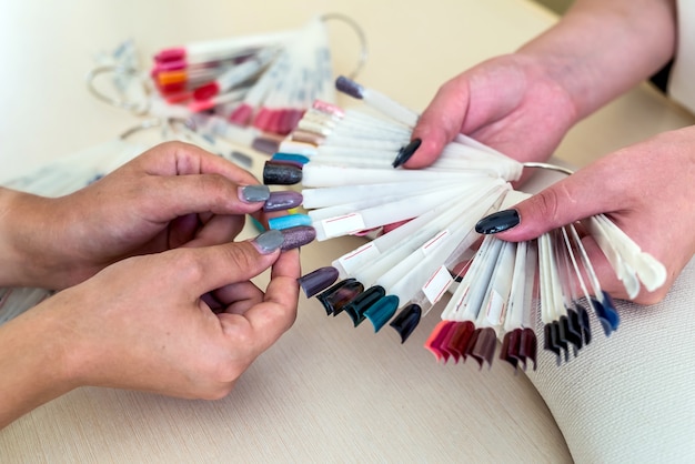 Female hands and colorful nail polish palette