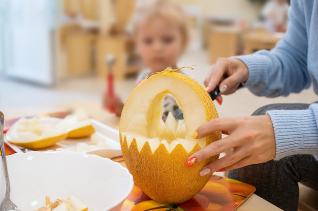 Female hands cutting pumpkin to halloween