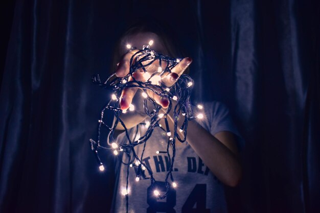 Female hands hold Christmas lights