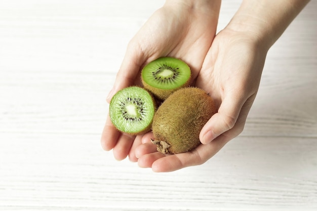 Female hands hold ripe kiwi