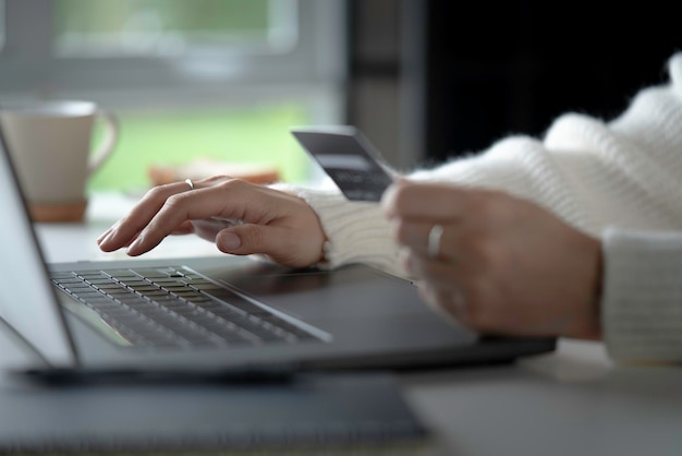 Female hands holding credit card and using laptop Online shopping