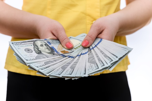 Female hands holding dollar banknotes in fan