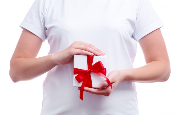 Female hands holding gift box with red bow