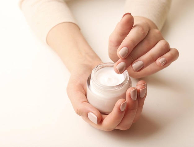 Female hands holding jar of cream isolated on white