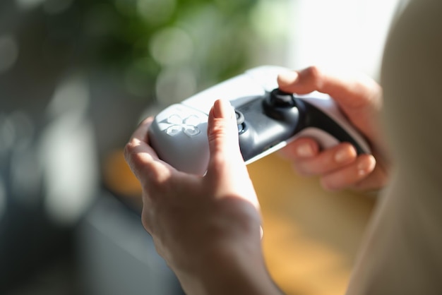 Female hands holding a joystick for the game closeup