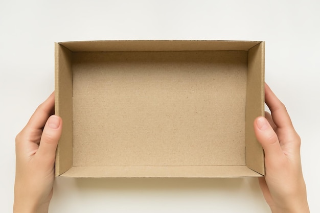 female hands holding an open cardboard box on a white background packaging and delivery concept