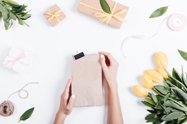 Female hands holding a paper bag with a gift