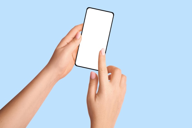 Female hands holding a phone with a blank screen on a blue background