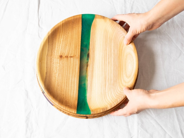 Female hands holding round wooden craft trays