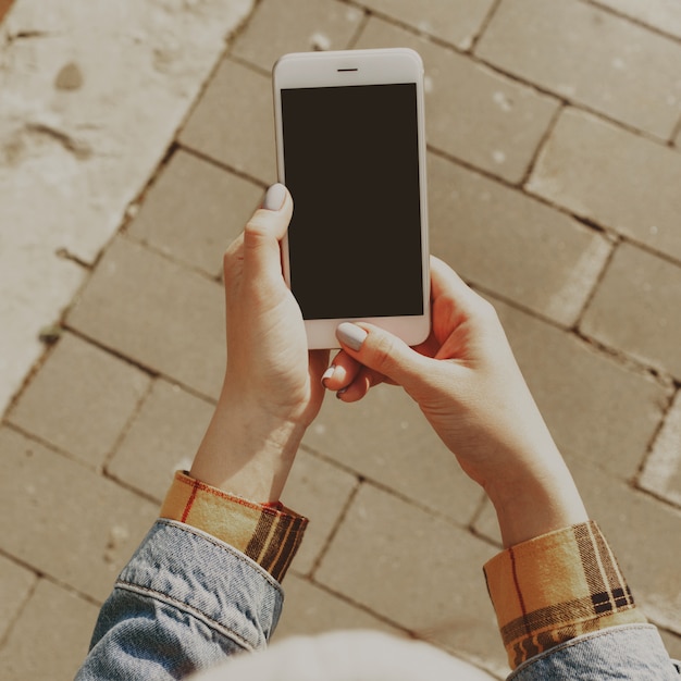 Female hands holding a smartphone with a blank screen