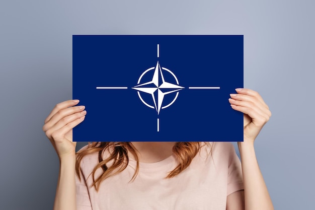 Female hands holds blank white speech bubble with nato flag