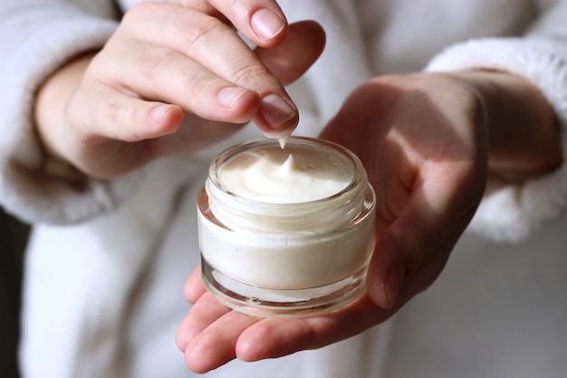 Female hands and jar of cream closeup with place to text