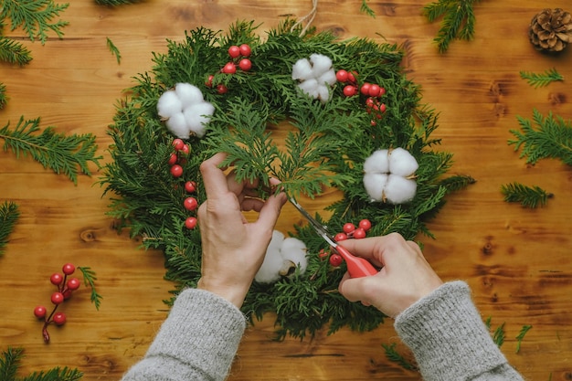 Female hands making Christmas wreath Overhead shot