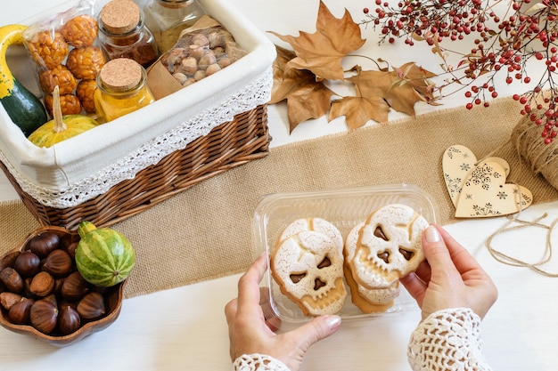 Female hands packing Halloween skull biscuits