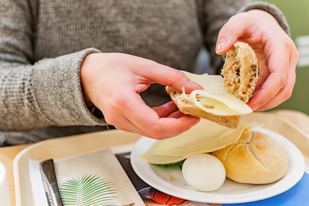 Female hands preparing a sandwich breakfast