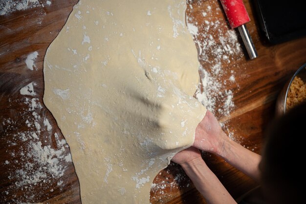 Female hands pulling and stretching a homemade vegan pastry dough