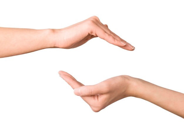 Female hands show gesture of protection on isolated white wall