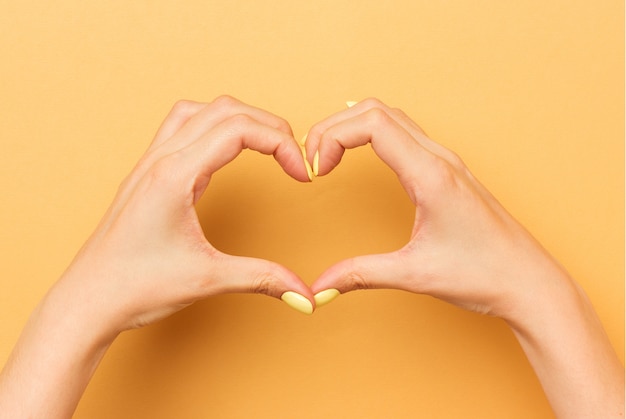 Female hands show a heart symbol isolated.