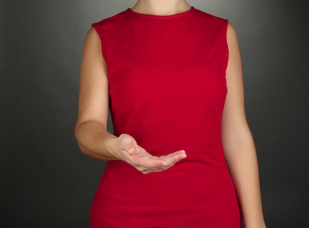 Female hands showing something on grey background