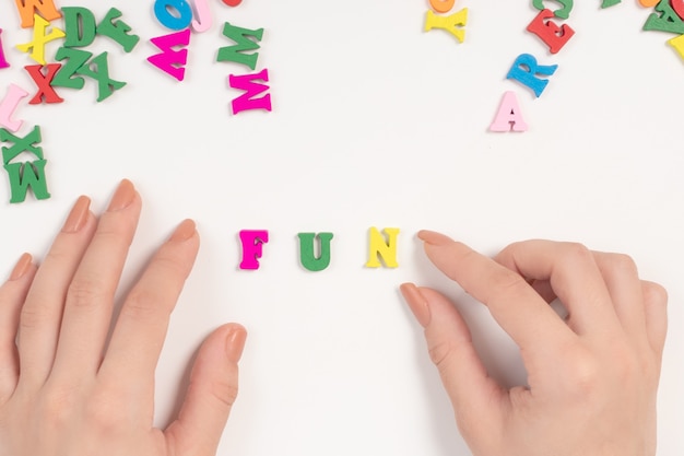 Female hands spread the word fun from colored letters