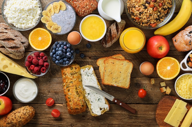 Female hands spreading butter on bread. Woman cooking breakfast. Healthy breakfast ingredients, food frame. 